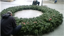A large holiday wreath lying on the ground 2