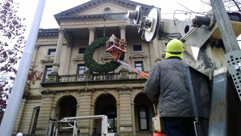 Hanging a large holiday wreath on a public building with a crane 7