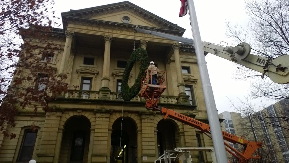 Hanging a large holiday wreath on a public building with a crane 6