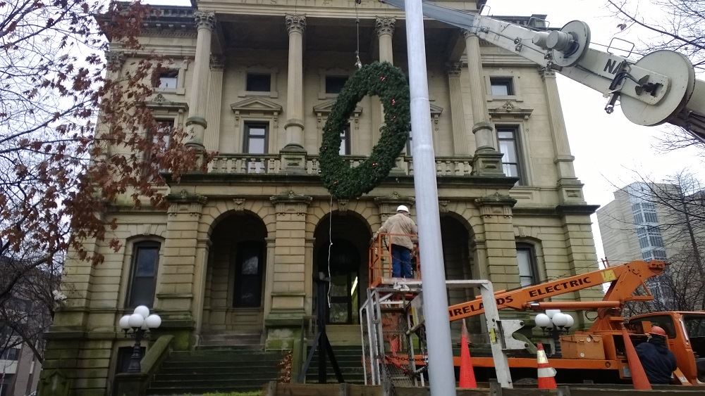 Hanging a large holiday wreath on a public building with a crane 5