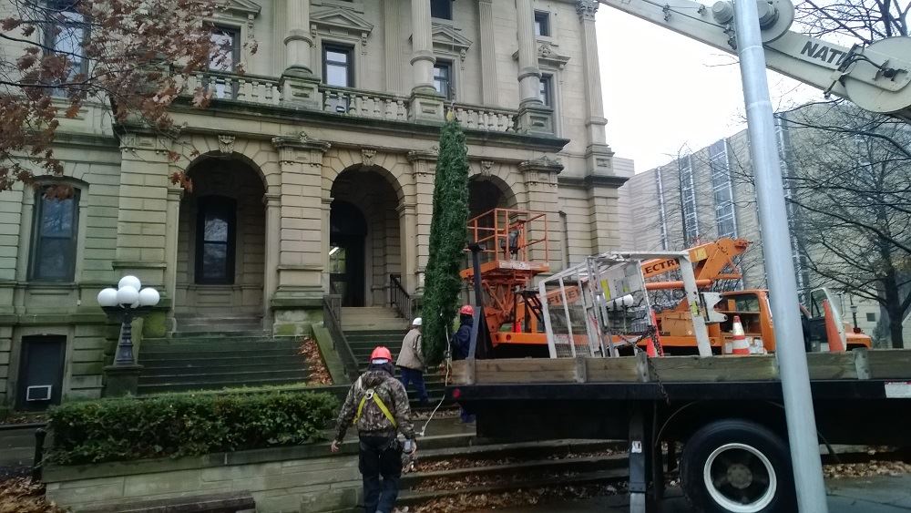 Hanging a large holiday wreath on a public building with a crane 2