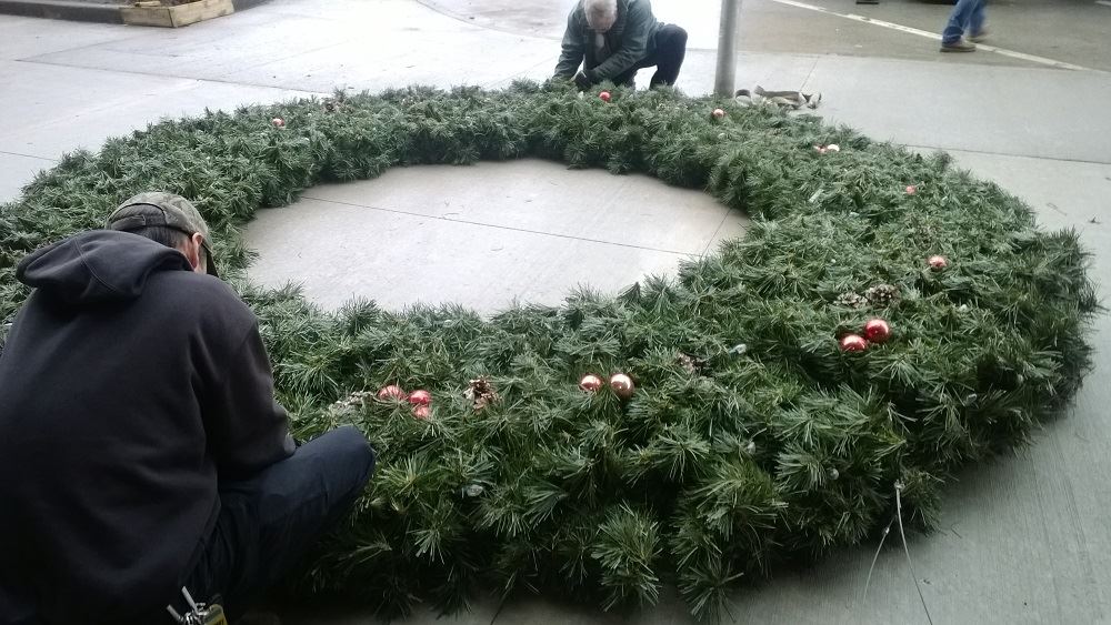 A large holiday wreath lying on the ground 2